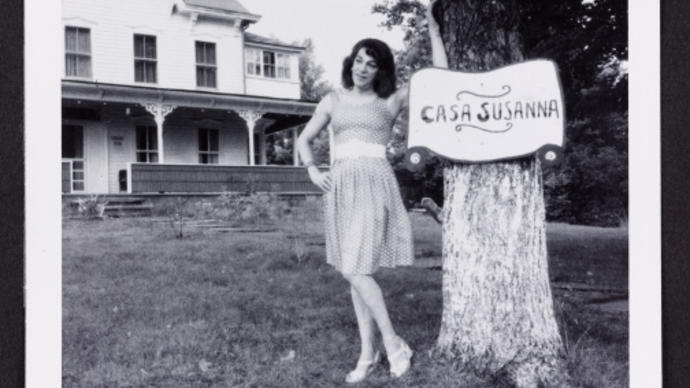 Black and white photo of person standing by a Casa Susanna sign
