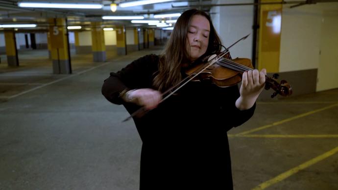 musician laura cannell performing in a car park