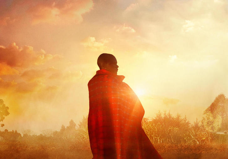 an image of samuel wrapped in a blanket with the sunset behind him