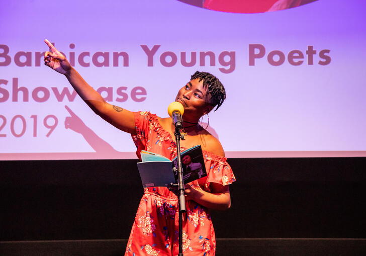 Image of previous young poets showcase. Black woman performing on stage.