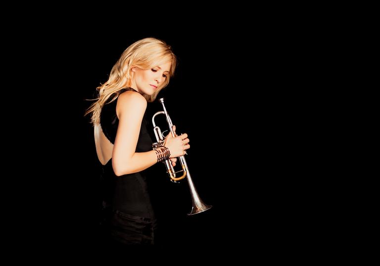 Alison Balsom holding trumpet black background