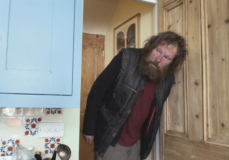 a homeless man pops his head through a kitchen door