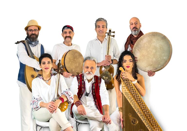 Rastak sit in all white outfits with their selection of instruments