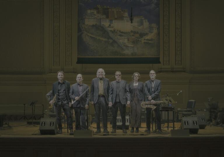 The Philip Glass Ensemble stand on stage at Carnegie Hall 