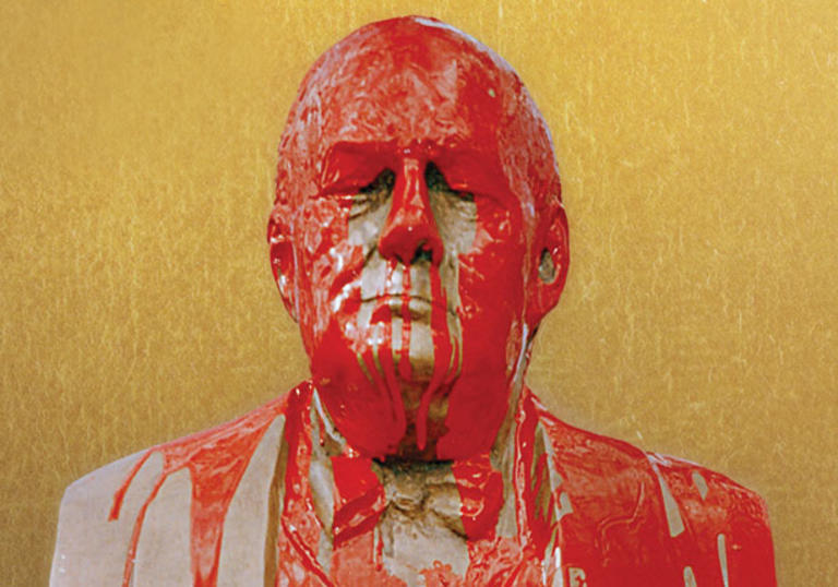 Photo of man covered in red paint against a yellow background