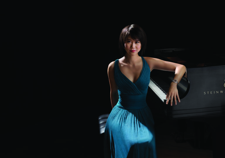 A colour photograph of Yuja Wang by a piano