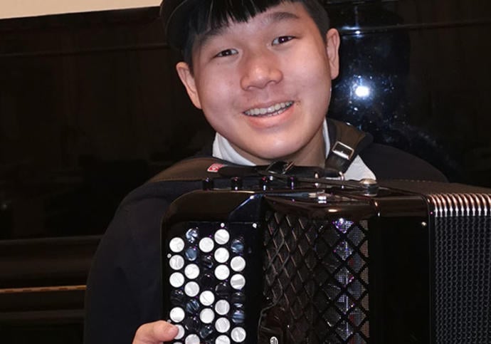 Smiling boy holding an accordion