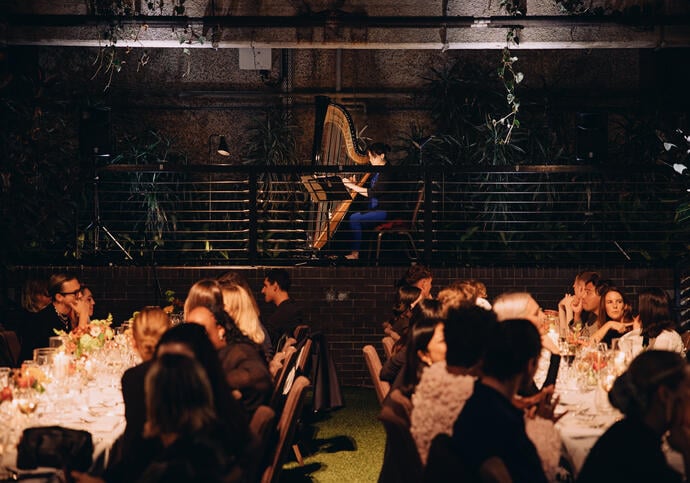 Image of seated dinner in Barbican Conservatory with harp playing