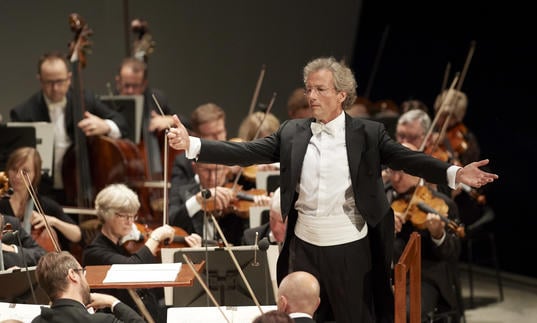 An image of Franz Welser-Möst conducting the Cleveland Orchestra with great enthusiasm