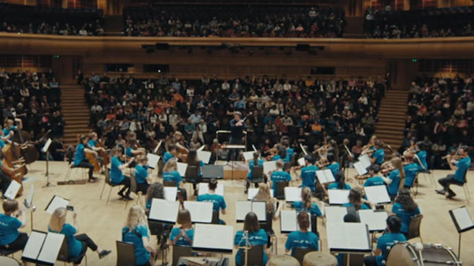 Photo of young people playing in an orchestra in the Barbican Hall