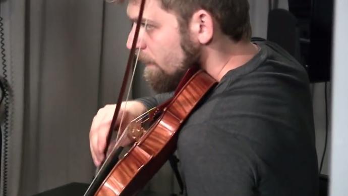 a still of a man playing the violin