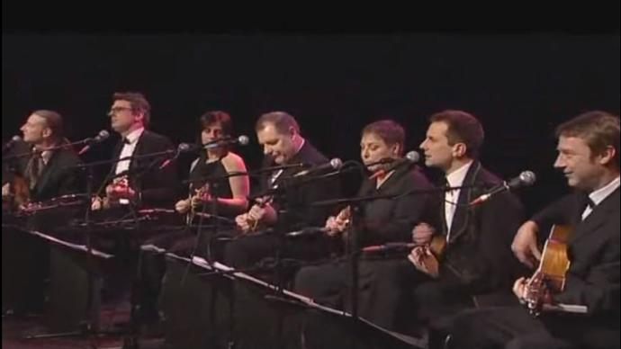 a photo of the ukulele orchestra of great britain performing at the barbican centre in london