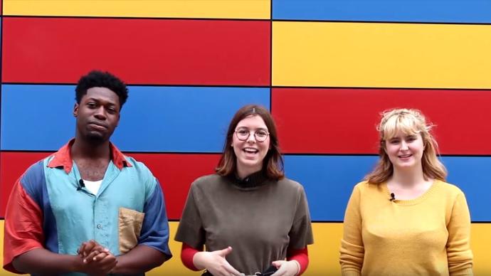 a photo of three teenagers standing in front of a colourful wall