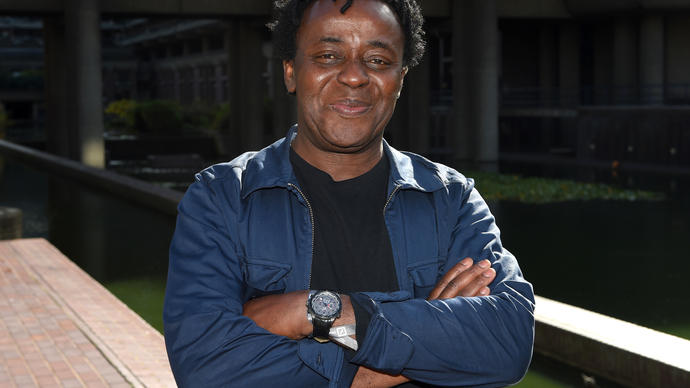 Photo of artist John Akomfrah by the Barbican lakeside