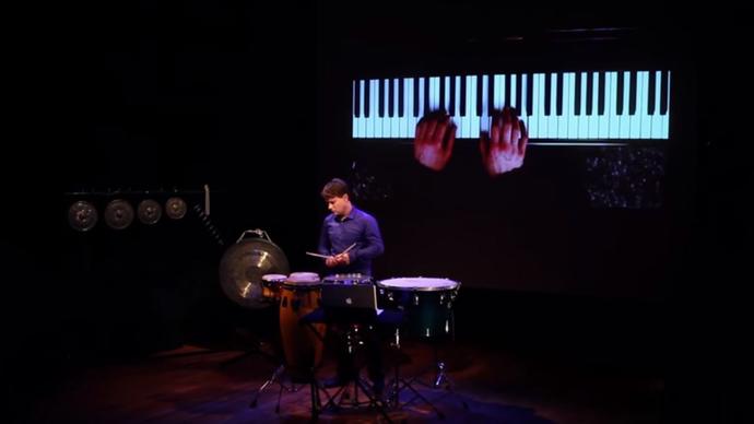 photo of man on stage playing instrument