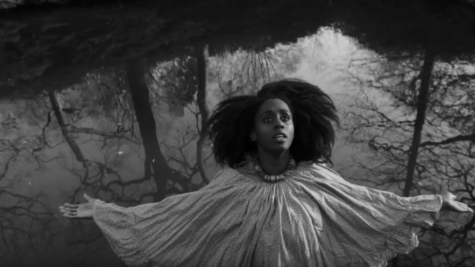 black and white photo of lady vendredi performing in the woods