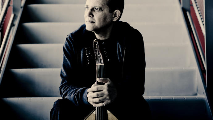 Anouar Brahem sitting on a staircase holding his oud