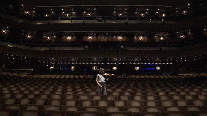 Woman with violin in an empty Theatre