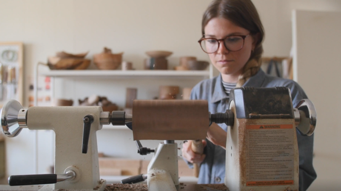 photo of elise mclaughlan turning wood with a wood machine