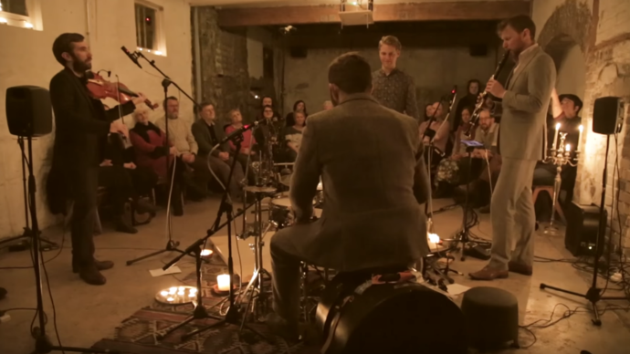 group of musicians playing music in dimly lit living room