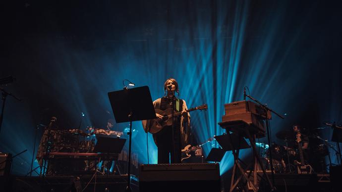 Karine Polwart singing and playing an acoustic guitar on stage