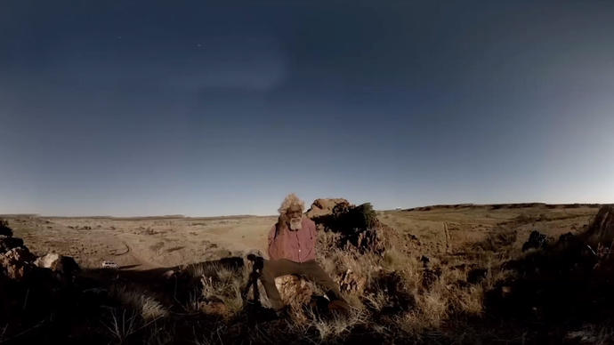 image of a man sitting in the desert