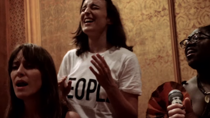 Photo of three women singing in a studio