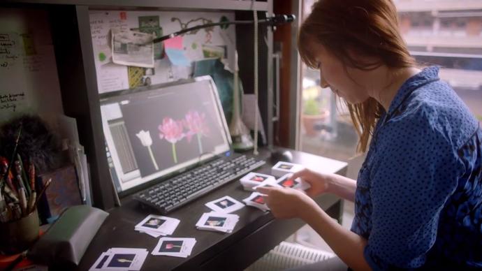 Woman looking at photographs of tulips by a computer