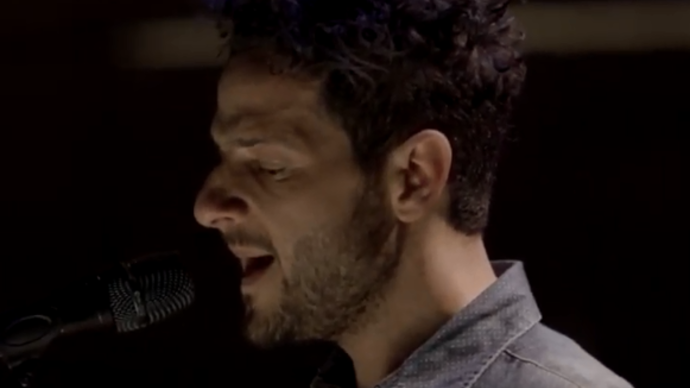 Photo of Lior singing into a microphone 