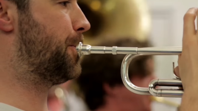 Close up photo of a  man playing the trumpet