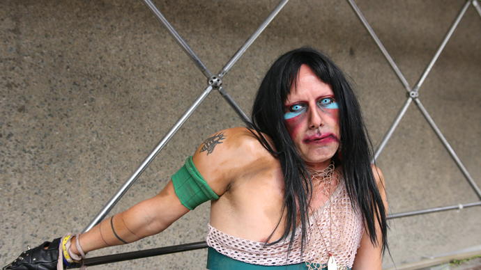 photo of CHRISTEENE posing against metal bars and a concrete background