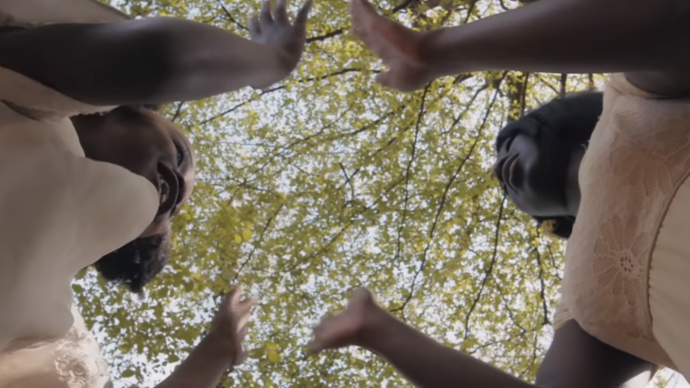 Low angle looking up at two young girls clapping their hands together