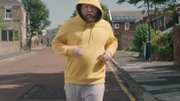 Photo of a man jogging in the middle of the road towards the camera