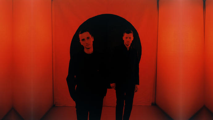 These New Puritans standing in a red room
