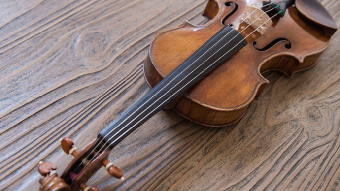 Photo of a violin laying on a wooden table
