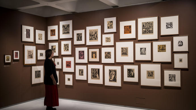 Woman looking at a series of small paintings