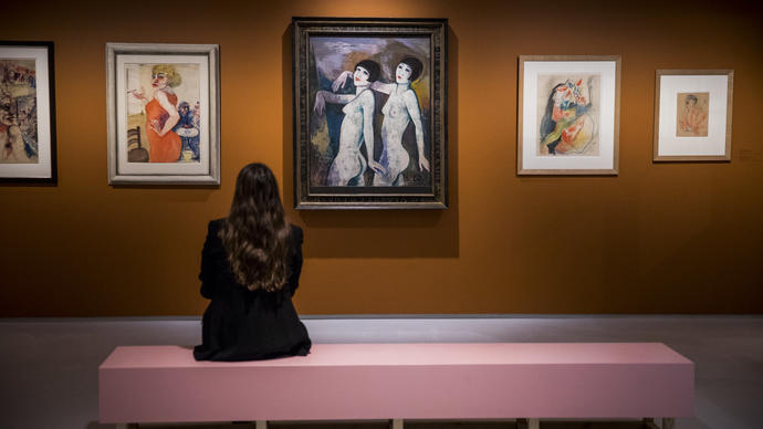 Woman looking at a painting of two figures