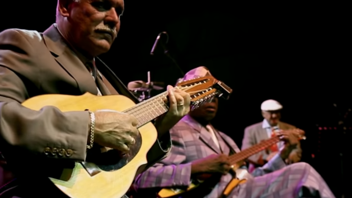 Photo of Eliades Ochoa playing the guitar