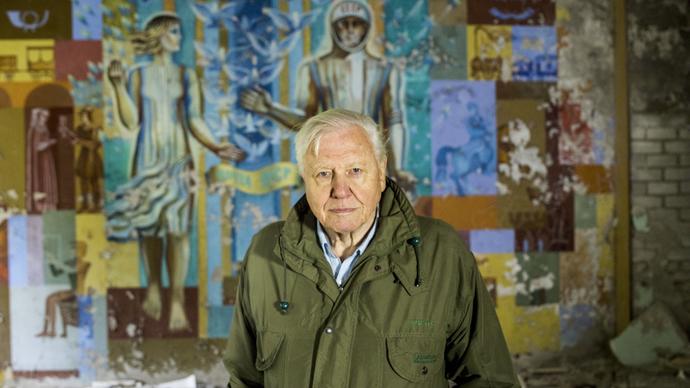 David Attenborough in front of a painted mural
