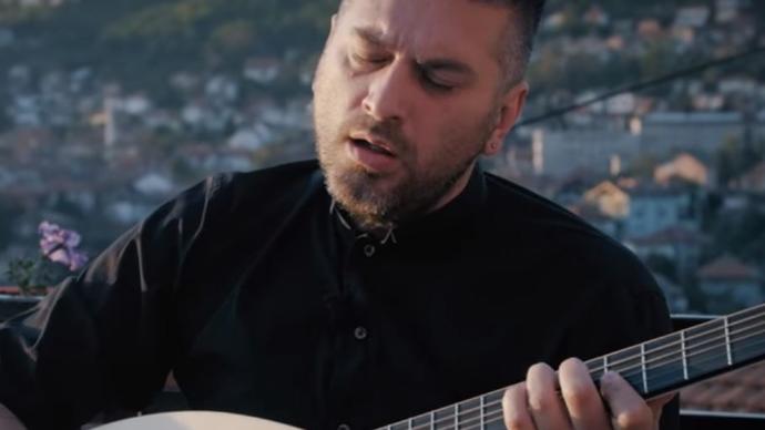Photo of Damir Imamović playing a guitar 