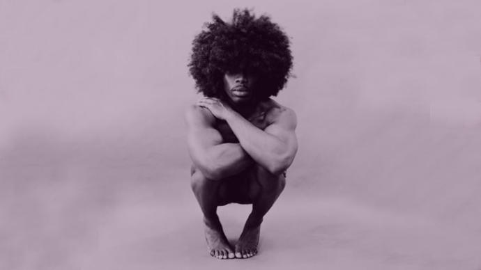 image of a naked black man holding his knees to his chest