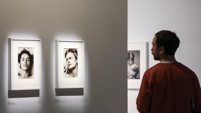 Man looks at two photos in gallery