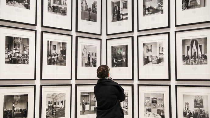 Woman looking at a wall filled with photographs