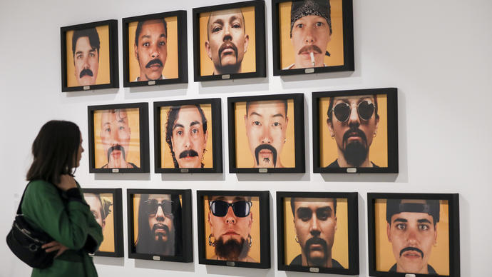 Woman looking at a wall filled with photographs