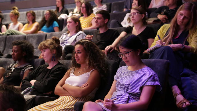 guests sitting in the cinema 1 listening to a speaker