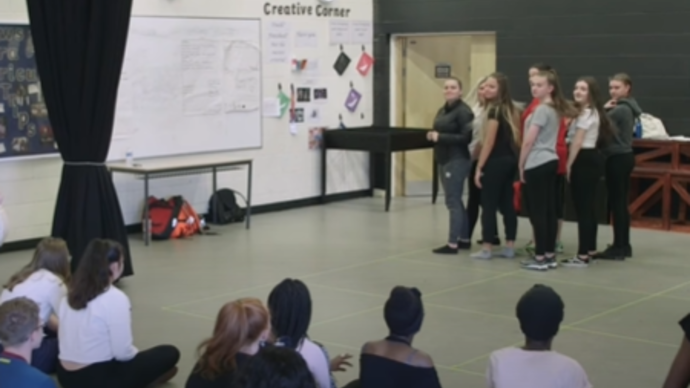 Group of teenagers performing to their class mates