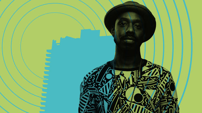 Shabaka Hutchings with a silhouette of the Barbican behind him