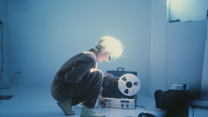 A woman kneels down in front of a recorder