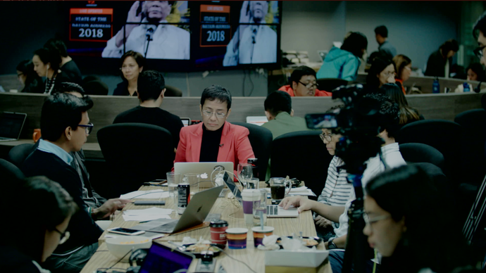 a group of people sit around a conference table