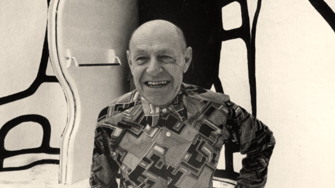 black and white photo of jean dubuffet smiling against some sort of wall with giant black lines